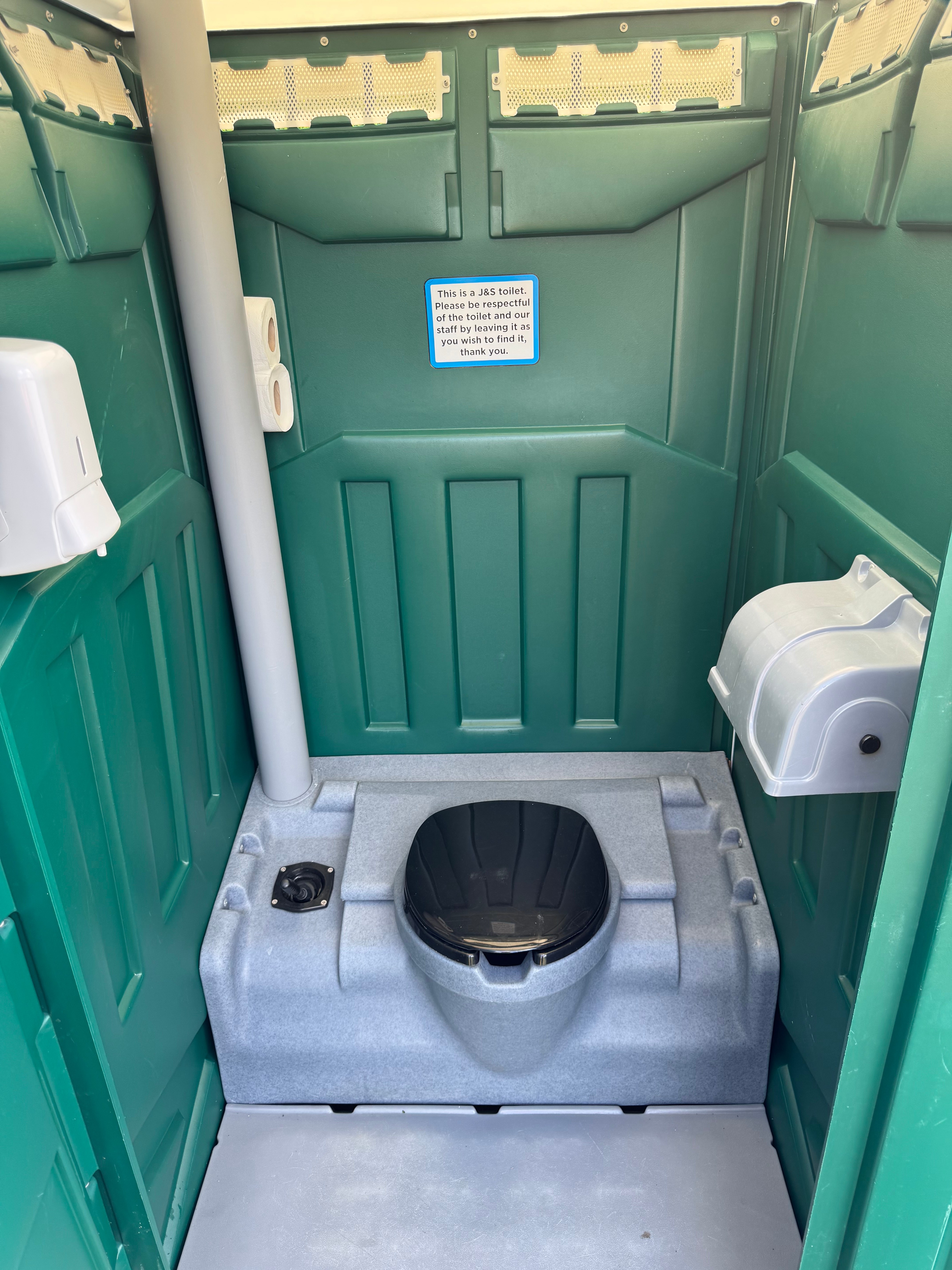 Interior view of construction portable toilet showing facilities and J&S Toilet Hire branding